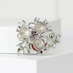 Detailed back view of red pomegranate brooch with silver alloy pin and safety clasp