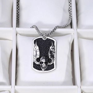 Macro view of punk style rectangular shield pendant with skull and devil wings relief