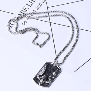 Detail of a punk-style skull with wings pendant and heavy round link stainless steel chain