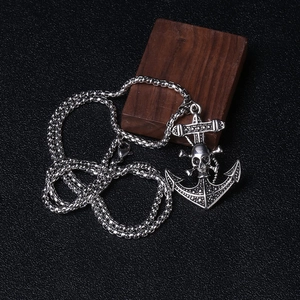 Detail of vintage anchor skull pendant on round box chain with antique silver finish