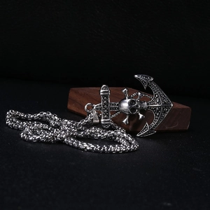 Close-up of retro silver pirate anchor skull pendant on a square pearl chain