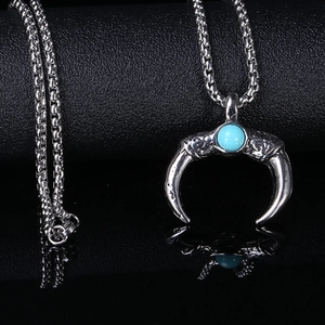 Mens turquoise crescent moon pendant necklace with silver box chain on black mirror surface