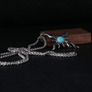 Detail of vintage silver titanium cross pendant with blue turquoise stone and thick box chain