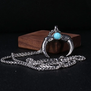 Detailed close-up of vintage silver crescent moon pendant with blue turquoise stone