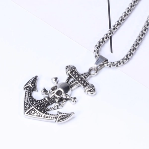 Close-up of vintage pirate skull and anchor pendant with gothic distressed silver finish