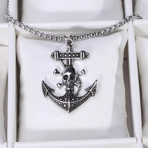 Macro view of vintage silver pirate skull anchor pendant with durable round box chain link