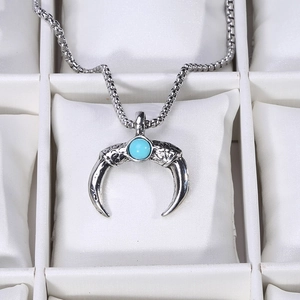 Macro shot of an antique silver moon pendant with a blue turquoise stone and engraved details