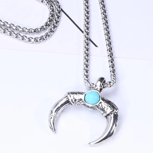 Detailed close-up of a vintage crescent turquoise pendant necklace with intricate engraving