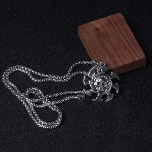 Détail d'un pendentif tête de mort punk avec motifs de flammes sur cuir noir