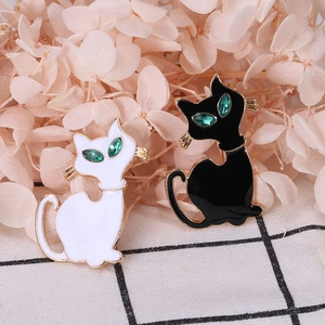 Charmante emaille kattenbroche set in zwart en wit met groene edelstenen ogen en goud