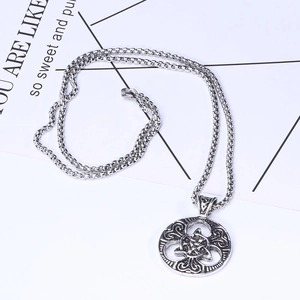 Detailed macro view of antique silver Celtic knot round pendant with a box chain necklace