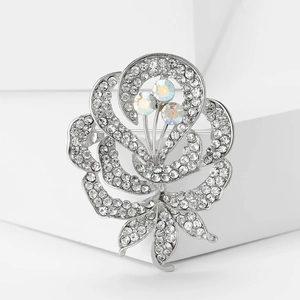 Détail macro d'une broche fleur en strass avec pétales argentés et cristaux AB colorés