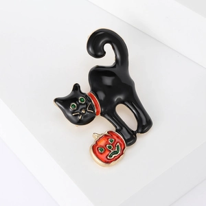 Halloween black cat brooch with orange pumpkin and green eyes on white background