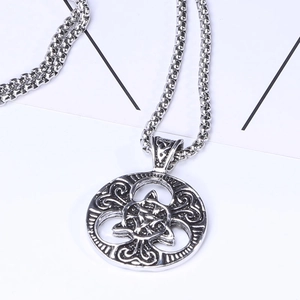 Close-up of vintage Celtic knot pendant with antique silver finish on a round link chain