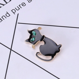 Macro-opname van elegante zwarte emaille kattenbroche met groene edelstenen ogen