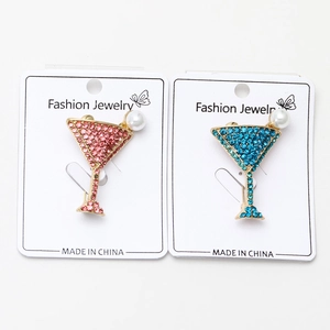 Détail de broches en verre à martini avec strass roses et bleus et détails de perles