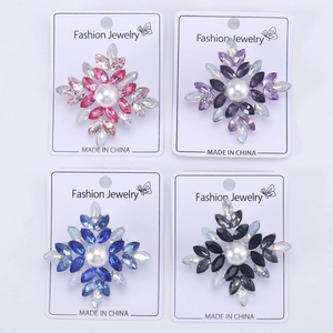 Detailed grid view of four crystal snowflake brooches with central pearls in various colors