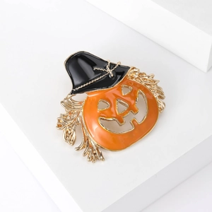 Halloween pumpkin brooch with black witch hat and gold-plated details on white pedestal