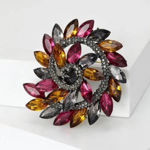 Macro detail of vintage floral brooch with radiant swirls and multicolored rhinestones