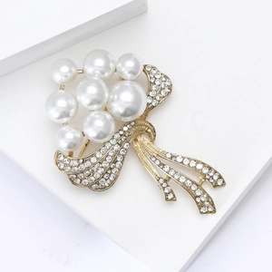Vue macro d'une broche fleur dorée avec perles blanches et strass étincelants