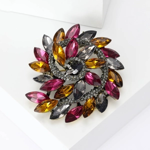 Detail of colorful marquise crystal flower brooch with vintage spiral design and gold finish
