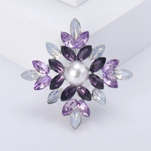 Macro detail of starburst brooch with purple rhinestones and central white pearl