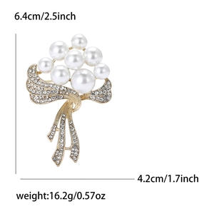 Broche nœud élégante avec perles et strass, dimensions 6,4x4,2cm sur fond blanc épuré
