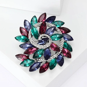 Macro detail of a vintage floral spiral brooch featuring colorful marquise-cut rhinestones