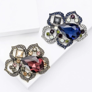 Broches de amapola vintage con cristales de lujo sobre fondo de mármol blanco