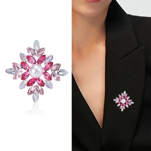 Elegant floral brooch featuring pink crystal petals and a central white pearl on black suit
