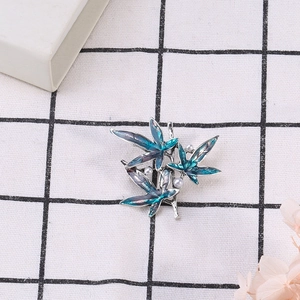 Macro detail of bamboo leaf brooch with blue-purple enamel and three elegant pearls