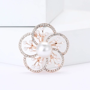 Elegant rose gold flower brooch with pearls and rhinestones on a white geometric block