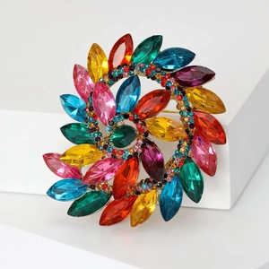 Detailed macro of a gold spiral brooch with colorful marquise rhinestones and crystals