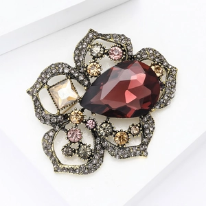 Detalle de broche de amapola vintage con gran cristal rojo en forma de gota y diamantes