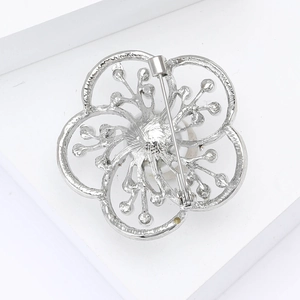 Detailed back view of silver flower brooch with hollow petals and secure pin fastener