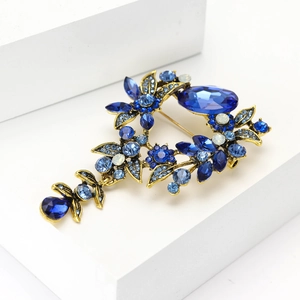 Détails macro de la broche vintage en alliage doré avec strass bleus et glands en cristal