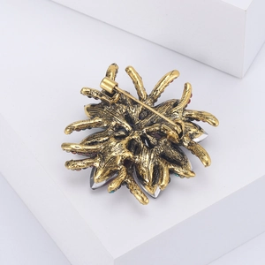 Detail view of the vintage gold flower brooch back with secure pin and colorful crystals