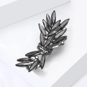 Detailed view of luxury crystal brooch with charcoal grey marquise gems in feather shape