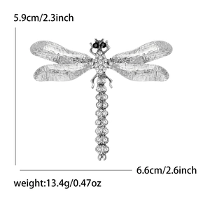 Vue détaillée des dimensions de la broche libellule en strass de 5,9 cm sur 6,6 cm