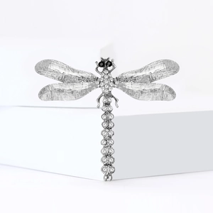 Élégante broche libellule avec strass blancs et finition argentée sur fond blanc