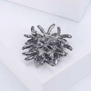 Detail view of the gunmetal flower brooch back showing the secure safety pin fastener