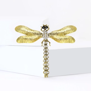 Broche libellule dorée élégante avec des ailes texturées et des cristaux blancs sur fond blanc