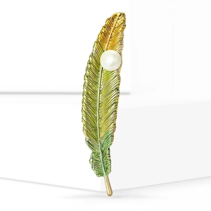 Vintage feather brooch with pearl detail in gold-teal gradient for elegant coats