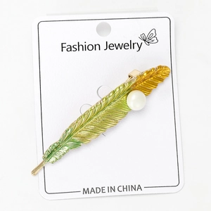 Detailed macro view of the alloy feather brooch with green gradient enamel and pearl