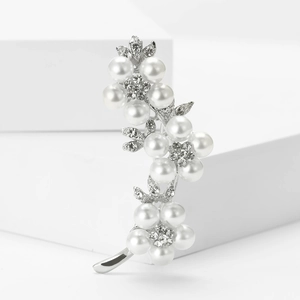 Vue détaillée de la broche fleur argentée avec perles blanches et strass étincelants