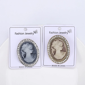 Detail view of retro alloy cameo brooches featuring rhinestone borders and queen portraits