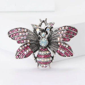 Macro view of vintage silver butterfly brooch with pink rhinestones and center opal stone
