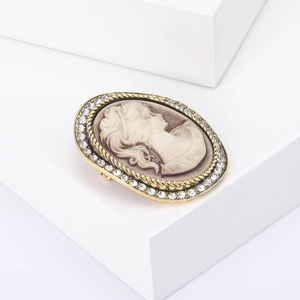 Macro shot of vintage cameo brooch with golden frame and sparkling rhinestones