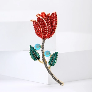 Élégante broche tulipe dorée avec strass rouges, verts et bleus sur des blocs blancs