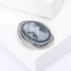 Vintage oval cameo brooch featuring a female profile with sparkling rhinestone border